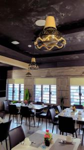 a dining room with tables and chairs and a chandelier at Emirates Star Hotel & Suites in Asaba