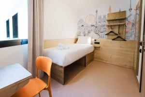 a small room with a bed and a chair at easyHotel Alicante Centro in Alicante