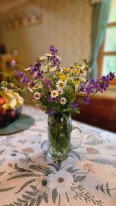 a vase filled with flowers sitting on a table at Hiša Vasenka in Laze v Tuhinju