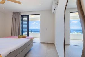 a bedroom with a bed and a view of the ocean at Villa Dushi Brisa 650 - Coral Estate in Willibrordus +19 photos