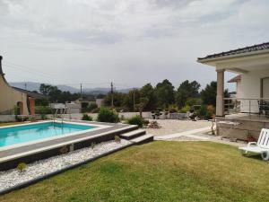 a backyard with a swimming pool and a house at Villa Beco - Moradia de Luxo com até 6 Quartos e Piscina Privada in Monção