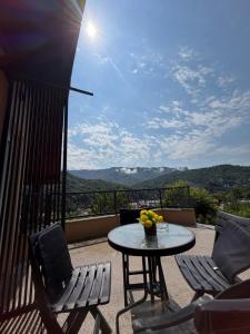 a table and chairs on a balcony with a view at Forest home in Konjic