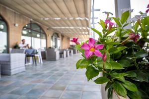 a vase filled with pink flowers in a lobby at Hotel Centro Congressi Polo Nautico in Salerno +102 photos