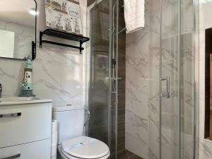 a bathroom with a toilet and a glass shower at R2R - Casa Gatu - 307A in Cudillero +30 photos