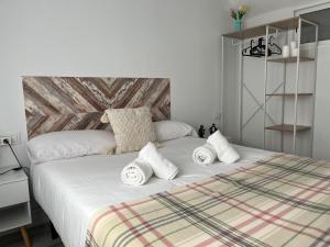 a bedroom with a bed with white sheets and pillows at R2R - Casa Gatu - 307A in Cudillero