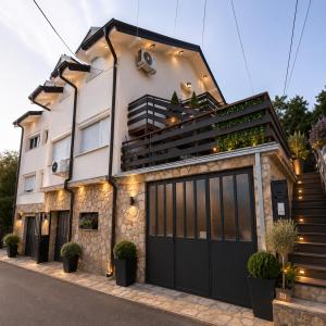 a house with black garage doors on a street at Garden lux in Belgrade