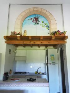 a kitchen with a shelf with flowers on it at Visit San Teodoro in San Teodoro