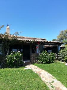a house with a garden and a grass yard at Visit San Teodoro in San Teodoro