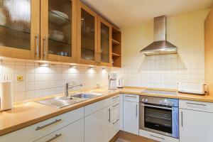 a kitchen with white cabinets and a sink at Ferienhaus Katharina in Zingst