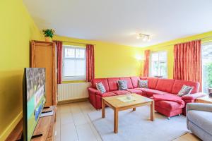 a living room with a red couch and a tv at Ferienhaus Katharina in Zingst