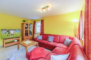 a living room with a red couch and a tv at Ferienhaus Katharina in Zingst