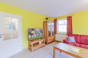 a living room with a red couch and a tv at Ferienhaus Katharina in Zingst
