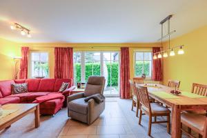 a living room with a red couch and a table at Ferienhaus Katharina in Zingst +33 photos