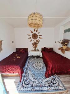 a room with two beds and a table in it at BOHO House in Cholpon-Ata