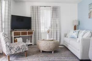 a living room with a white couch and a tv at 9 Palms Boutique Condos in Myrtle Beach