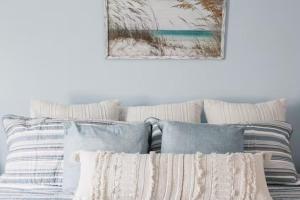 a pile of pillows on a bed with a picture on the wall at 9 Palms Boutique Condos in Myrtle Beach