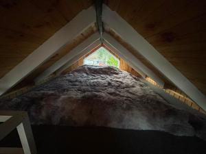 a large bed in a room with a window at Dyl Tiny House con Jacuzzi in Puerto Montt
