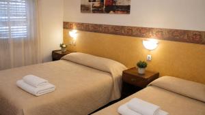 a room with two beds with towels on them at Hotel Gran Lucerna in Valle Hermoso +2 photos