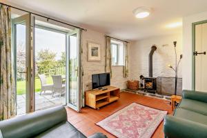 a living room with a tv and a fireplace at Swallow Cottage in Cowbridge