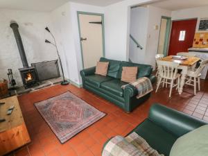 a living room with a couch and a fireplace at Swallow Cottage in Cowbridge