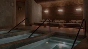 a room with two beds and a hot tub at Wake Medellin, a Member of Design Hotels in Medellín