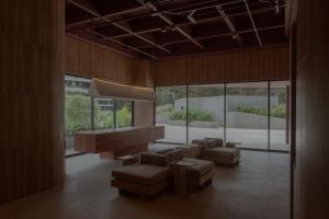 a living room with couches and chairs and windows at Wake Medellin, a Member of Design Hotels in Medellín