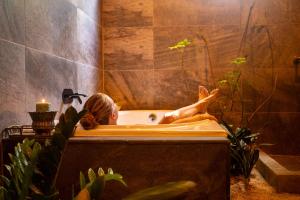 a woman laying in a bath tub with her feet up at Samaya Wellness Lodge in Flores +55 photos
