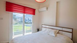 a bedroom with a white bed and a window at Villa Peri Luxury Pool Villa in Karşıyaka in Nicosia