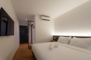 a bedroom with a white bed and a tv at T Hotel SP Pekan Lama in Sungai Petani