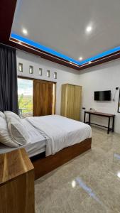 a bedroom with a large bed with a window and a desk at Payas Private Farm Villa in Praya