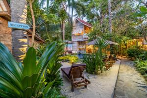 a resort with a table and chairs and trees at Ortigia Tropical Lodge in Gili Trawangan
