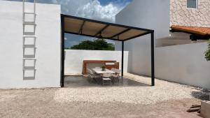 eine Terrasse mit Tisch und Stühlen in einem Gebäude in der Unterkunft Casa Lirio in Chuburná