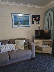 a living room with a couch and a flat screen tv at Bramston beach resort in Bramston Beach