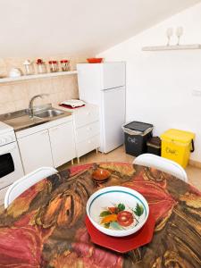 a kitchen with a table with a plate of food on it at MANSARDA COSTA BIANCA - Free Parking in Realmonte +2 photos
