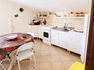 a kitchen with a table and a sink at MANSARDA COSTA BIANCA - Free Parking in Realmonte