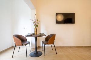 a table with four chairs and a tv on a wall at Green Emerald in Haifa
