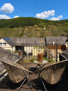 a patio with two chairs and a table on a roof at Galerie Riesling in Trittenheim