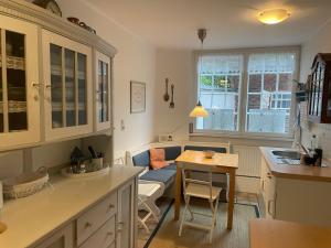 a kitchen with a table and a living room with a couch at Ferienwohnung Am Mittelburgwall in Friedrichstadt