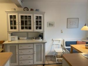 a kitchen with a cabinet and a table and chairs at Ferienwohnung Am Mittelburgwall in Friedrichstadt +14 photos