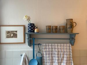 a shelf with vases and a picture on a wall at Ferienwohnung Am Mittelburgwall in Friedrichstadt