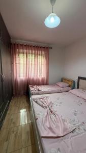 a bedroom with two twin beds and a window at Ulëz Nature Apartment in Ulëz
