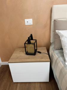 a nightstand next to a bed with a lamp on it at Il Ligustro by Roberto in San Giovanni Lupatoto