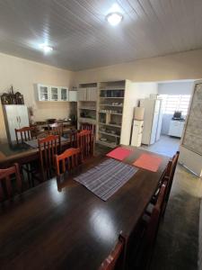 a kitchen and dining room with a large wooden table at Pousada Veadeiros - Alto Paraiso de Goiás in Alto Paraíso de Goiás