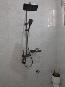 a shower in a bathroom with a hair dryer on the wall at IGAWILO RESIDENCE Hotel in Dodoma +47 photos