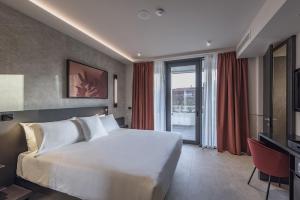 a bedroom with a large bed and a large window at Palazzo Vittoria Hotel Milano in Milan