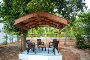 a wooden pavilion with chairs and a table under it at Hidden Heaven Villa in Puducherry Airpoert