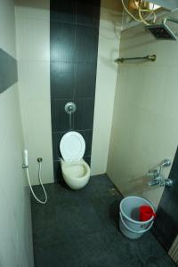 a bathroom with a toilet and a bucket in it at Hidden Heaven Villa in Puducherry Airpoert