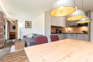 a kitchen and a living room with a wooden table at Haus Alpenrose in Serfaus