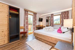 a bedroom with a bed and a tv and windows at Haus Alpenrose in Serfaus