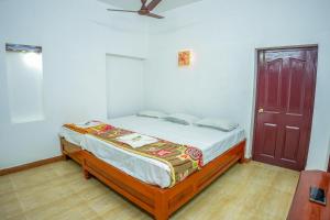 a bedroom with a bed and a brown door at Hidden Heaven Villa in Puducherry Airpoert